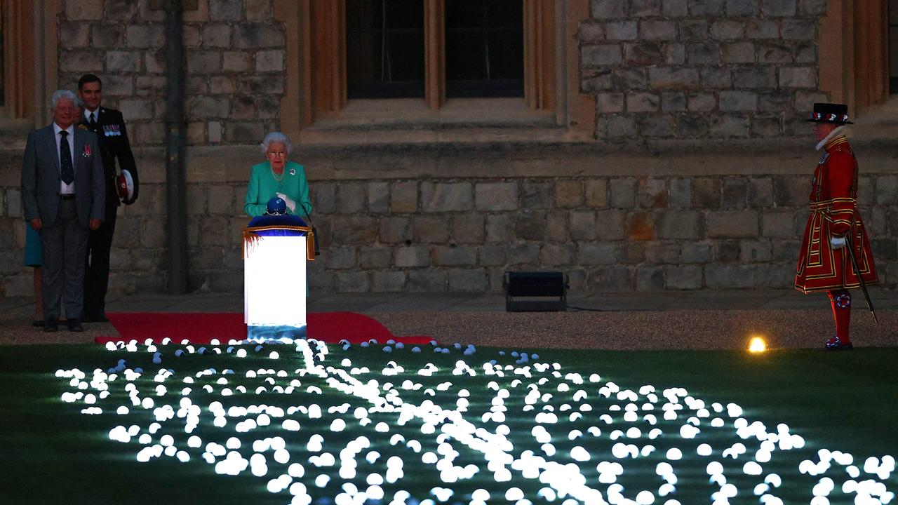 Britain's Queen Elizabeth II touches the Commonwealth Nations Globe to start the lighting of the Principal Beacon. Picture: AFP