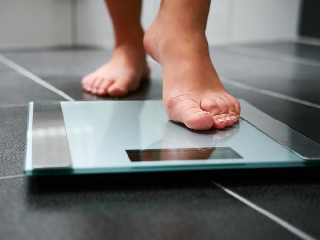 Female bare feet with weight scale in the bathroom, scales generic