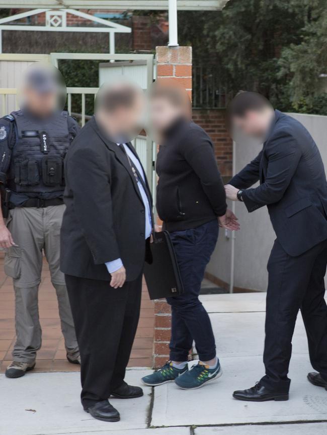 Adam Cranston is escorted from the scene at Bondi yesterday. Picture: Police Media.