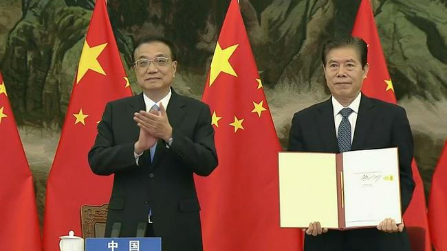 China’s Premier Li Keqiang, left, applauds as Chinese Minister of Commerce Zhong Shan holds up the agreement during the signing ceremony for the Regional Comprehensive Economic Partnership (RCEP) trade pact at the ASEAN summit. Picture: AFP