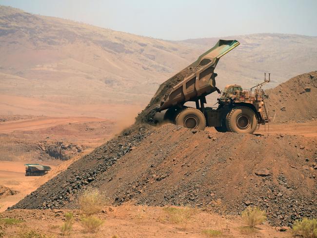 An autonomous haul truck dumps a load of rock in the mine pit at Rio Tinto Group's Gudai-Darri iron ore mine in the Pilbara region of Western Australia, Australia, on Thursday, Oct. 19, 2023. Rio Tinto is preparing for trials of battery-powered locomotives in Australia, where it uses giant autonomous trains — the world’s largest and longest robots — to transport iron ore across the vast Outback. Photographer: Carla Gottgens/Bloomberg