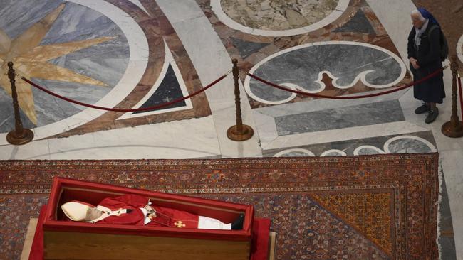 Sister Genevieve Jeanningros prays in front of the body of late Pope Francis inside St. Peter's Basilica at the Vatican, Wednesday, April 23, 2025, where he will lie in state for three days. (Alessandro Di Meo/ Pool Photo via AP)