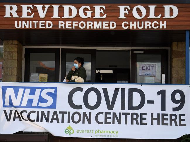 A person stands by a banner advertising a COVID-19 vaccination centre in Blackburn, northwest England. Picture: AFP