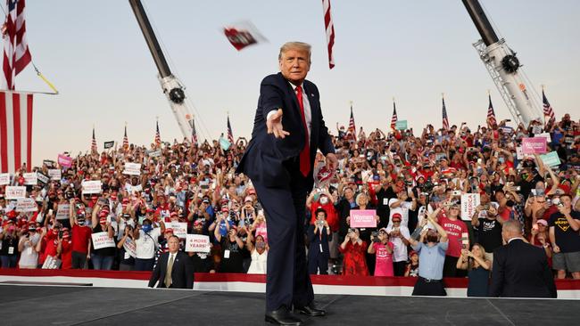 Donald Trump throws a mask at a campaign rally in Sanford, Florida, on Tuesday. Picture: Reuters