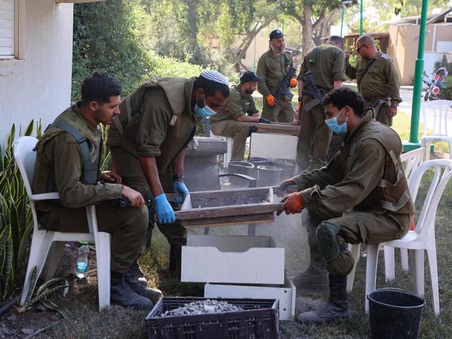 Israeli soldiers help archaeologists from the Israel Antiquities Authority sift through ashes from burnt out dwellings to identify residents who went missing during the October 7 attack my Hamas militants. Picture: Gil Cohen-Magen/AFP