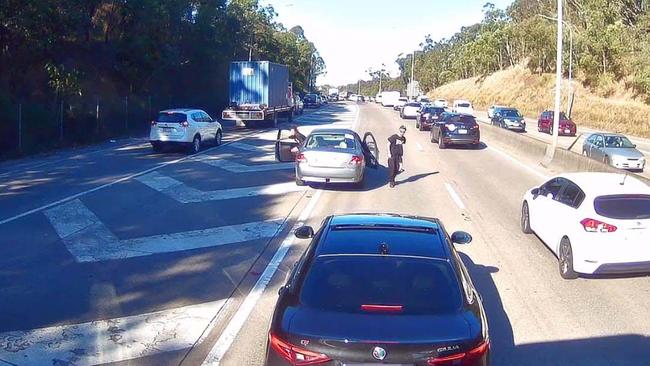 A man and woman exit their car on the M1 last Friday. Picture: Supplied.