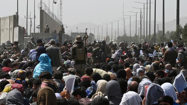 Afghans gather on a roadside near the military part of the airport in Kabul hoping to flee from the country after the Taliban's military takeover of Afghanistan. Picture: Wakil Koshar/AFP