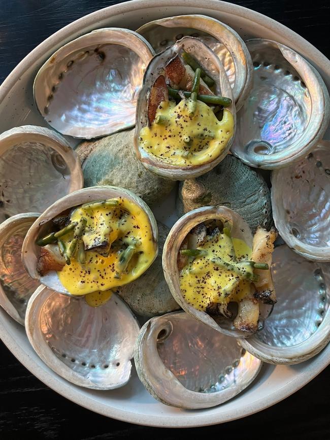 Sauteed abalone served in the shell on a bed of pearlescent shells and topped with a Tasmanian native saffron-scented sauce studded with sea asparagus from Coningham from the Leatherwood restaurant in DoubleTree by Hilton Hobart. Picture: Supplied