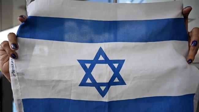 A woman displays an Israeli national flag during a rally to show solidarity to the people of Israel following the October 7, 2023, attack by Hamas. Picture: AFP