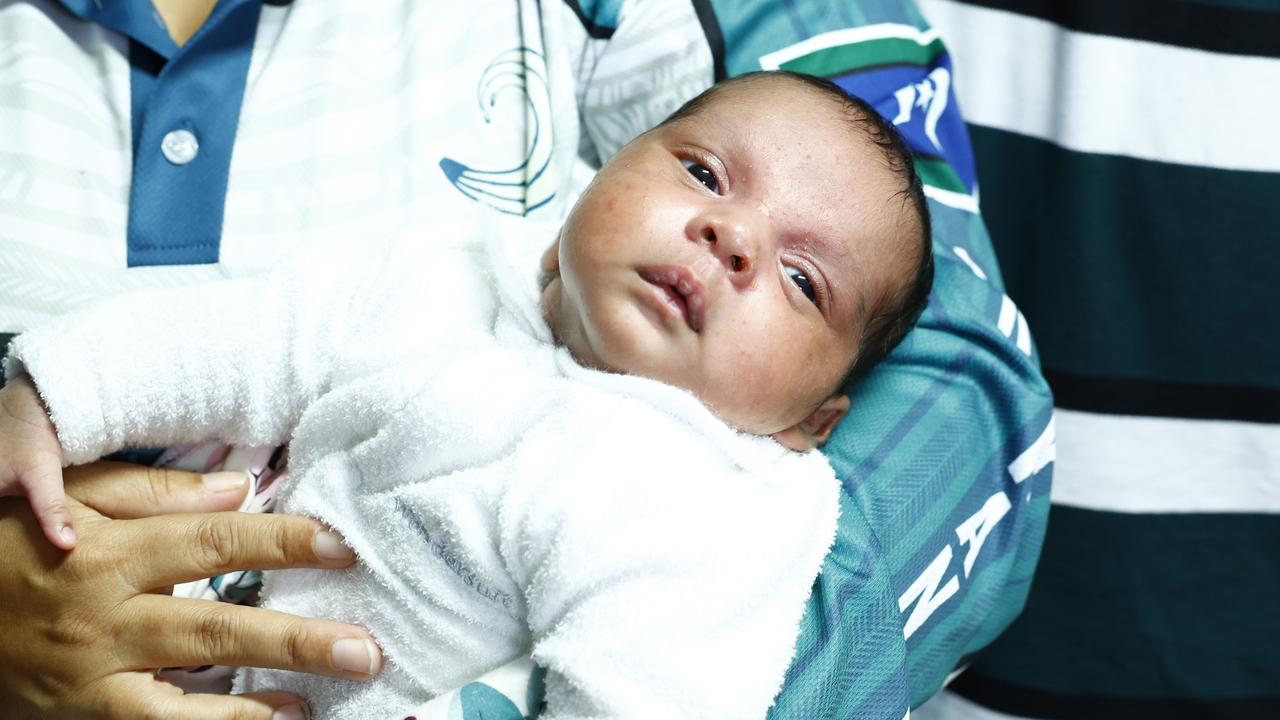 Pictured at the Holloways Hub, a volunteer-run meeting place for flood victims, baby girl Jadearna Creek is proudly nursed by friends and family. Picture: Brendan Radke