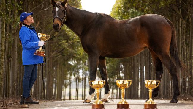 *HOLD FOR JUNE 8* MELBOURNE, JUNE 3, 2022: Three-time Melbourne Cup winner Makybe Diva pictured with her strapper Natalie Hinchcliffe, with her three Melbourne Cup trophies and the 2022 Lexus Melbourne Cup trophy. Picture: Mark Stewart