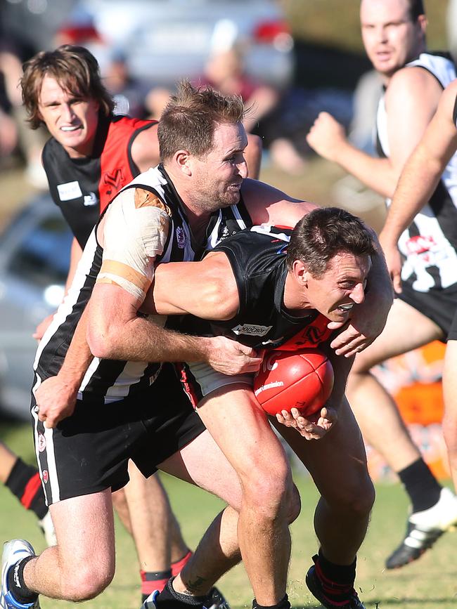 Shane Hill (Morphett Vale) is tackled by Ryan Frick (Reynella) during the second quarter. Reynella v Morphett Vale, at Reynella Oval. Southern Football League. Picture: STEPHEN LAFFER.