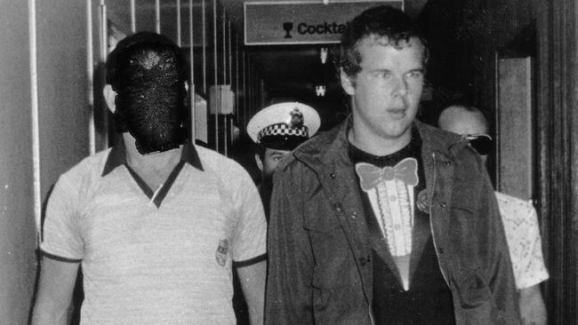 Murderer Andy Albury is led by detectives through the Darwin Airport. Albury was convicted of killing a woman in Darwin's Mitchell Street in November 1983 and mutilating her body. Circa: 8/1984.