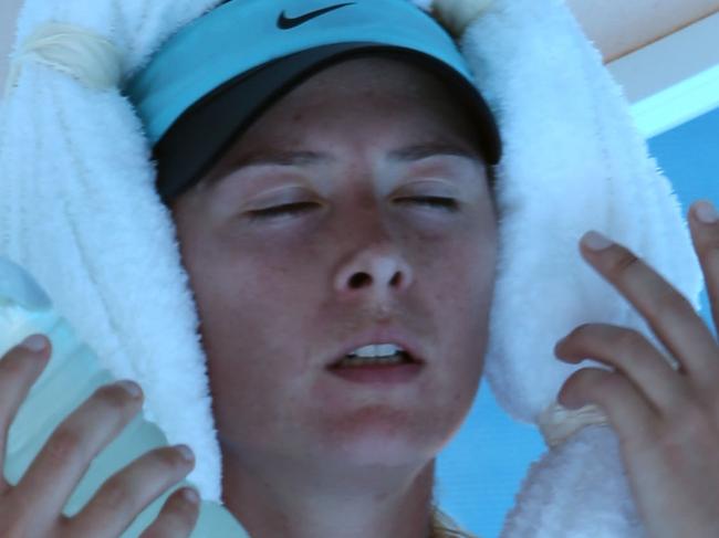 MELBOURNE, AUSTRALIA - JANUARY 16: Maria Sharapova of Russia cools off during a break in her second round match against Karin Knapp of Italy during day four of the 2014 Australian Open at Melbourne Park on January 16, 2014 in Melbourne, Australia. (Photo by Clive Brunskill/Getty Images)