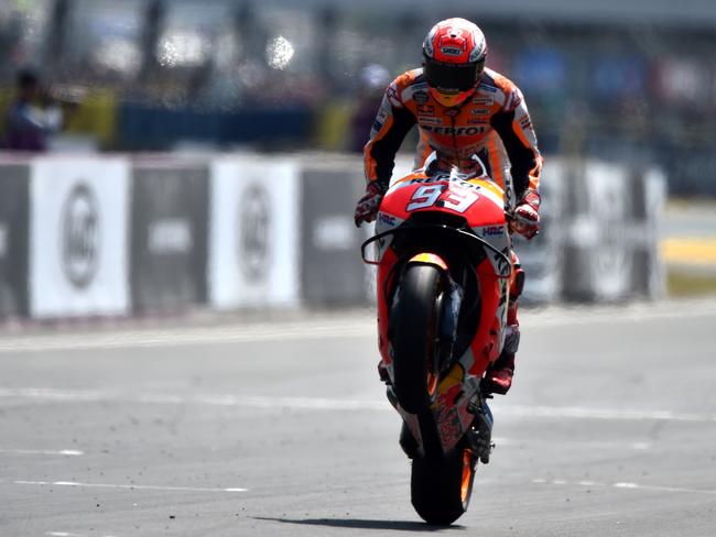 Marquez celebrates with a wheelie across the line.