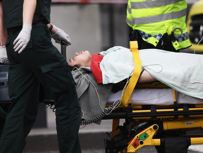 A member of the public is taken away for treatment by emergency services near Westminster Bridge and the Houses of Parliament. Picture: Carl Court/Getty Images