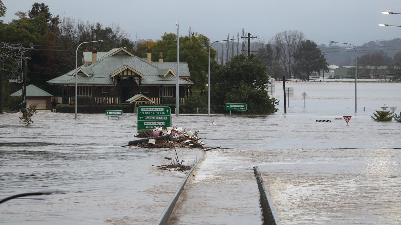 Daylight sees the Windsor Bridge under water and debris beginning to pile up on it. Picture: John Grainger