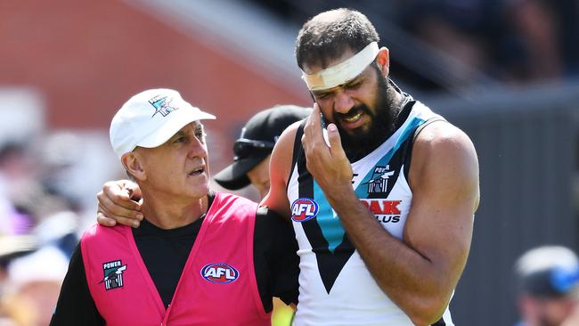 Port Adelaide’s Paddy Ryder is helped off the ground by a trainer in the last quarter during the 2019 JLT Community match against the North Melbourne Kangaroos at Alberton Oval. Picture: Mark Brake/Getty