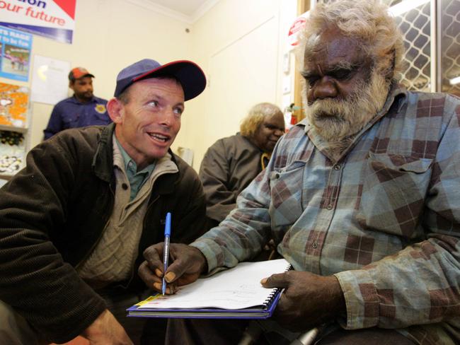 Mr Abbott in 2006 with Charlie Antjipalya, chairman of the Watarru Aboriginal community signing for a new swimming pool, on Pitjantjatjara lands in Central Australia.