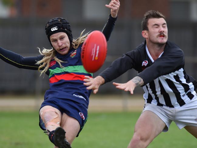 Northern Saints’ Matthew Gray gets a kick away while under pressure from Moonee Valley's Dillon Rogan. Picture: Josie Hayden