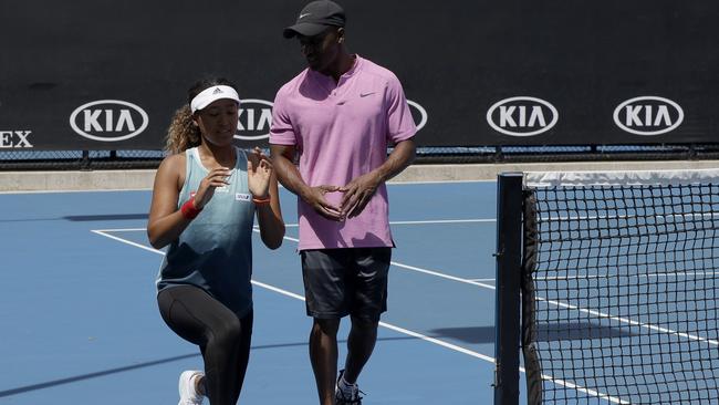 Japan's Naomi Osaka goes through warm-up exercises with her fitness coach Abdul Sillah 