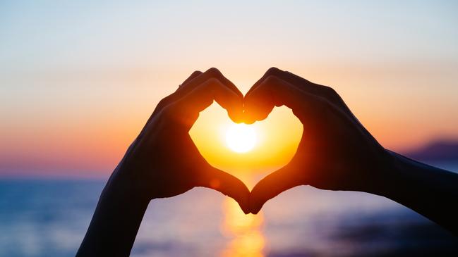 ESCAPE: Romance, Paul Ewart -  hands forming a heart shape with sunset silhouette. Copy space text. . Picture: iStock