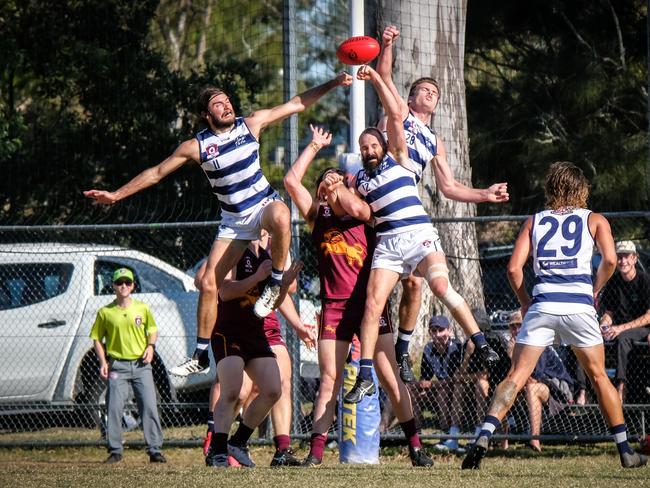 Broadbeach Cats QAFL players (from left) Sam Weddell, Josh Searl and James Royes contesting the ball with Palm Beach Currumbin player Brayden Crossley. Picture credit: Brooke Sleep Photography.