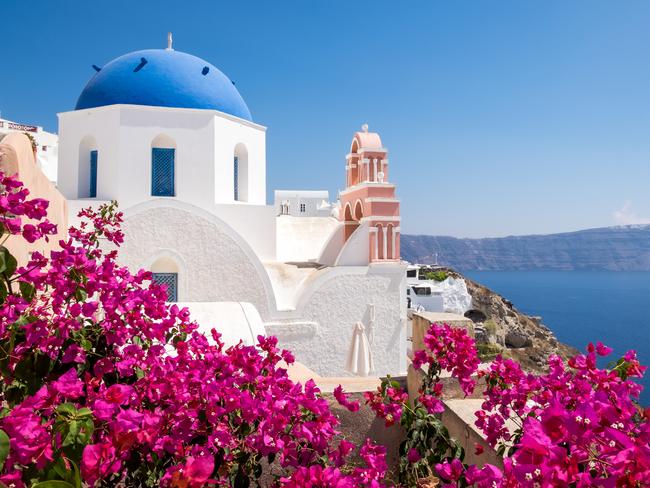 ESCAPE: Escape.com.au pointers. Scenic view of traditional cycladic houses with flowers in foreground, Oia village, Santorini, Greece. Picture: istock