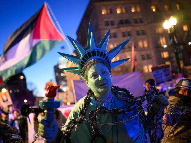 An activist dressed as the Statue of Liberty is pulled in shackles in support of Palestinians near the White House. Picture: AFP