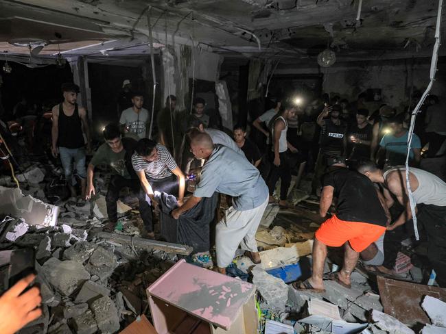 Rescuers and people search the home of Palestine TV journalist Mohamed Abu Hatab, who was killed along with family members during Israeli bombardment on Khan Yunis in the southern Gaza Strip. Picture: AFP