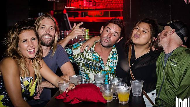 Foo Fighters drummer Taylor Hawkins (second from left) and entourage Tim Fly (middle) and Steve (right) at Shooters Nightclub on Sunday with locals Shylah Gibb (left) and Jess Joaquin (right).