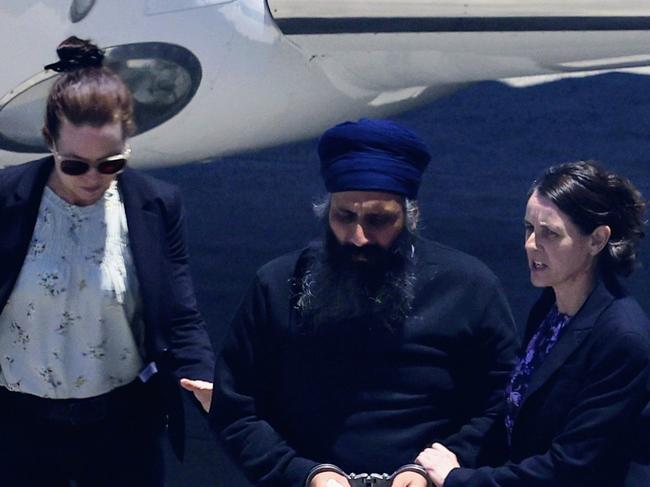 Queensland Police officers and detectives escort Rajwinder Singh from a chartered jet to a waiting police car at Cairns Airport after being extradited from New Delhi to Cairns via Melbourne. Rajwinder Singh left Australia for India the day after Toyah Cordingley was found allegedly murdered on Wangetti Beach in Far North Queensland in October 2018, and is the alleged key suspect in the murder case. Picture: Brendan Radke