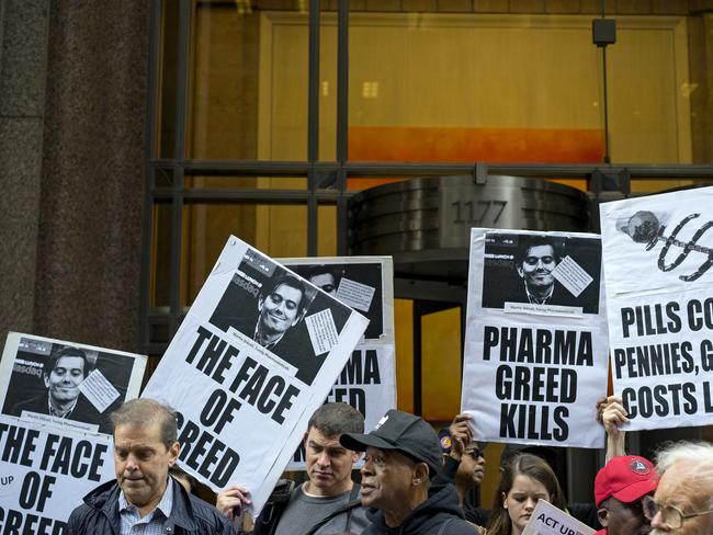 Activists hold signs containing the image of Turing Pharmaceuticals CEO Martin Shkreli in front the building that houses Turing’s offices, in New York. Picture: AP Photo/Craig Ruttle