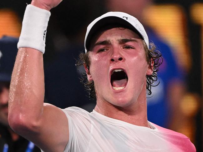 TOPSHOT - Brazil's Joao Fonseca celebrates beating Russia's Andrey Rublev in their men's singles match on day three of the Australian Open tennis tournament in Melbourne on January 14, 2025. (Photo by WILLIAM WEST / AFP) / -- IMAGE RESTRICTED TO EDITORIAL USE - STRICTLY NO COMMERCIAL USE --