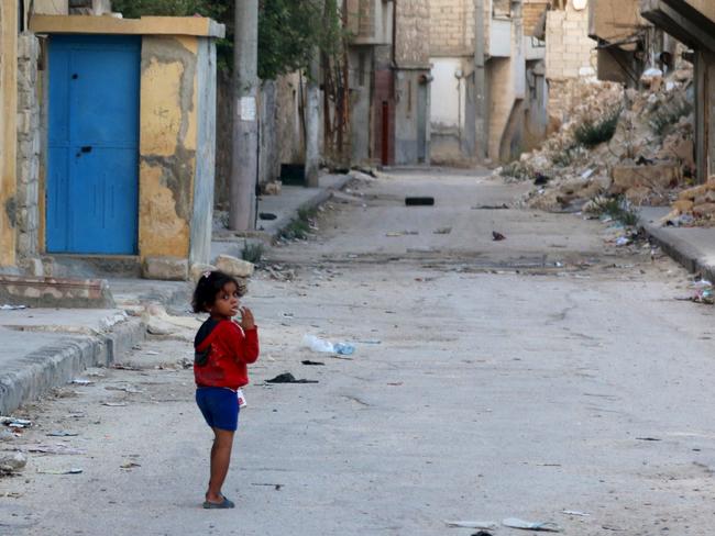 A girl walks along a deserted street in Tariq al-Bab neighbourhood of Aleppo, Syria. Picture: REUTERS/Abdalrhman Ismail