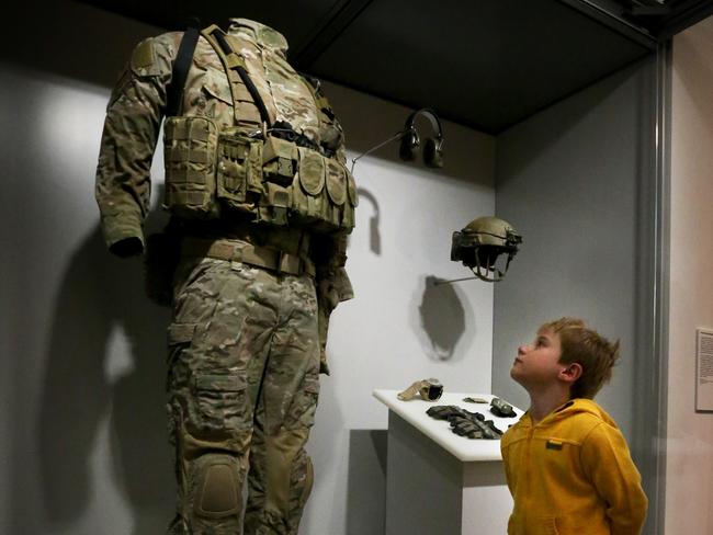 Five-year-old Max Taylor looks at the uniform worn by 2-metre tall Corporal Ben Roberts- Smith in Afghanistan.