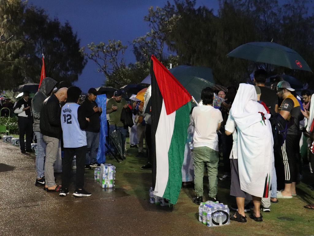 Protesters gathered at Surfers Paradise Esplanade despite torrential rain to call for an immediate ceasefire of bombing in the Gaza Strip. Picture: Amaani Siddeek