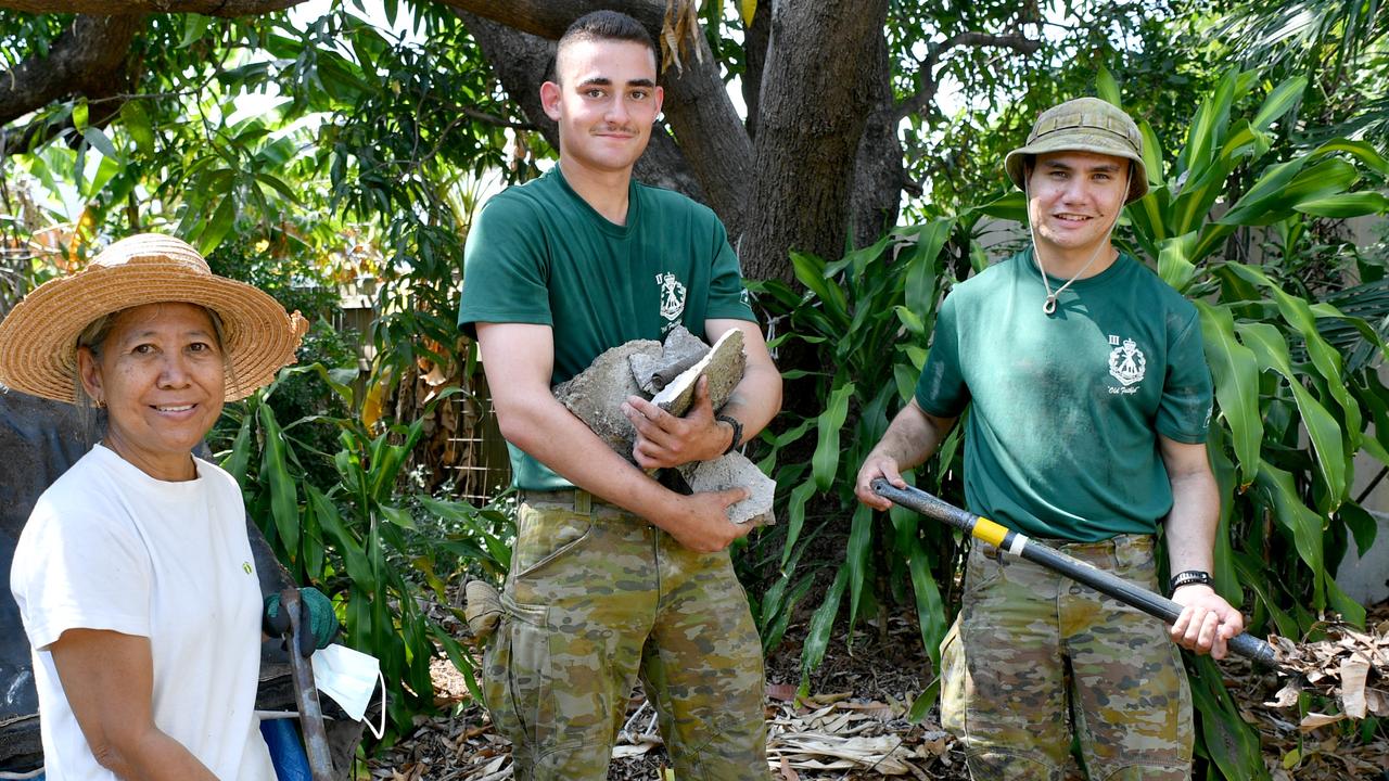 Emma Aldrdige gets help clearing up her backyard from 3RAR soldiers Private Deacon Whatuina and Private Vaughn Masina. Picture: Evan Morgan