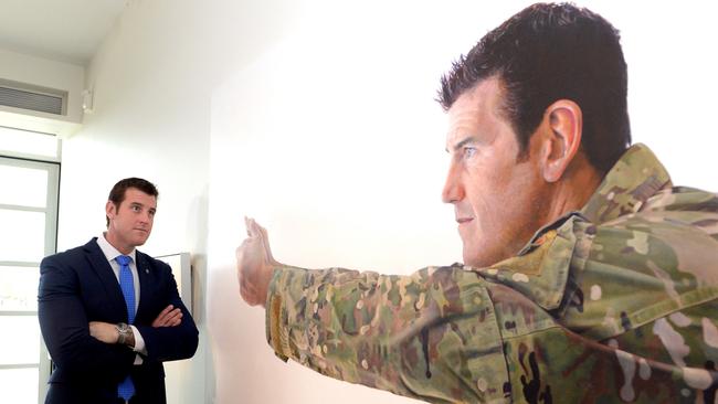 Roberts-Smith examines a portrait of himself at the Australian War Memorial in Canberra in 2014. Picture: AAP