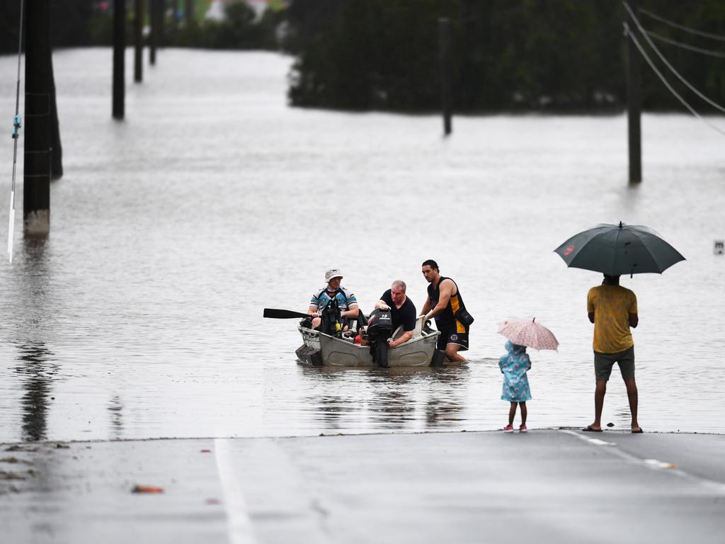 A father and his young daughter watch people take to flood water in their boat in Logan. (Photo by Dan Peled/Getty Images)