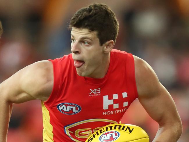 GOLD COAST, AUSTRALIA - MARCH 31: Chris Burgess of the Suns runs the ball during the round two AFL match between the Gold Coast Suns and the Fremantle Dockers at Metricon Stadium on March 31, 2019 in Gold Coast, Australia. (Photo by Chris Hyde/Getty Images)