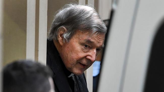 Australian Cardinal George Pell (C) is escorted in handcuffs from the Supreme Court of Victoria in Melbourne on August 21, 2019. - Disgraced Catholic Cardinal George Pell was sent back to jail after an Australian court rejected his landmark appeal against convictions for child sex abuse. (Photo by William WEST / AFP)