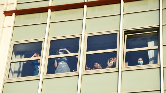 National Health Service doctors look out of the window of a Covid-19 ward as they participate in a national ‘clap for carers’ to show thanks for the work of Britain's NHS in 2020. Picture: AFP