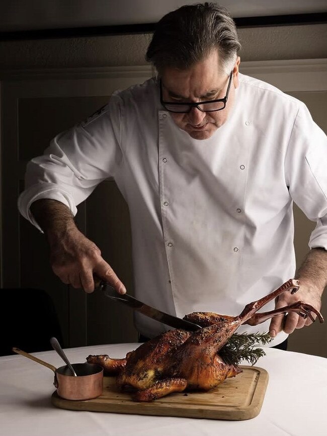 Chef Guy Grossi carves one of Xavier’s pasture-raised cockerels. Picture: Supplied