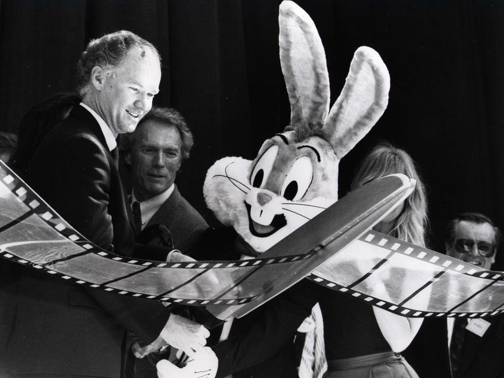 Premier Wayne Goss cuts the film at the opening of Movie World — actor Clint Eastwood (C) actress Goldie Hawn hidden by scissors. Picture: Supplied