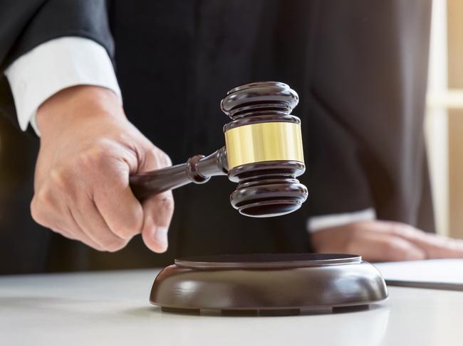 Close up of Male lawyer or judge hand's striking the gavel on sounding block, working with Law books, report the case on table in modern office, Law and justice concept.