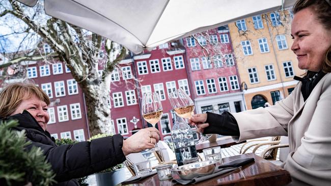 Guests enjoys a glass of wine outside Huks Fluks cafe in Copenhagen, Denmark. Picture: AFP