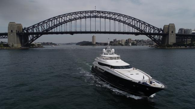 Sydney Harbour Bridge gives an indication of the size of the luxury superyacht Mischief, which is available for hire.