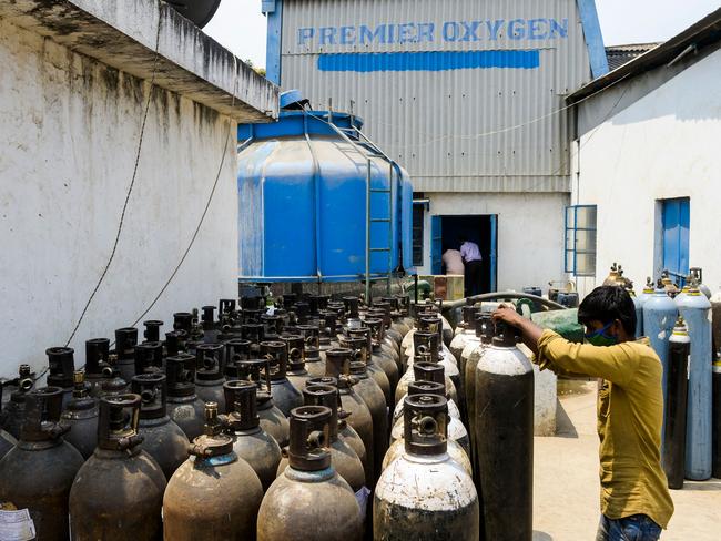 A worker arranges medical oxygen cylinders to transport to hospitals for the coronavirus treatment in a facility on the outskirts of Hyderabad, India. Picture: AFP