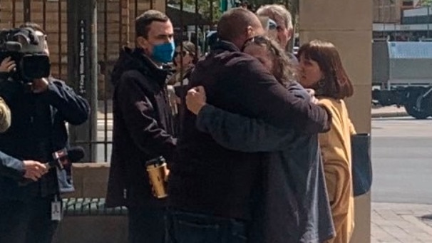 Toby Lockyer (left) is comforted outside court by a supporter after his partner Solange Goodes was granted bail. Picture: Ben Cameron.